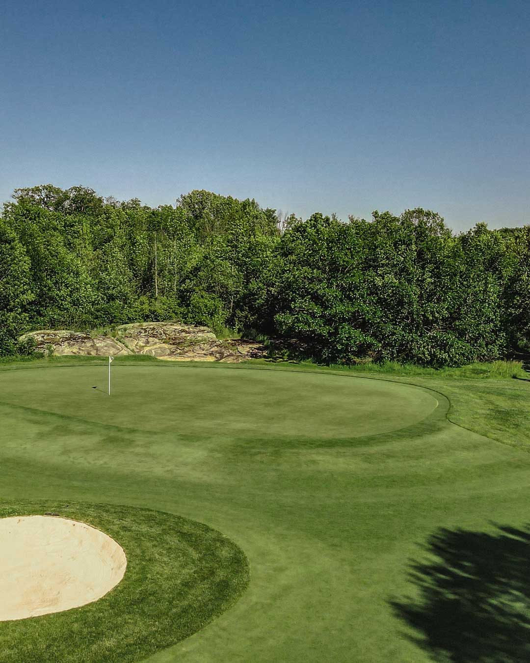 Muskoka golf green with bunker and rock