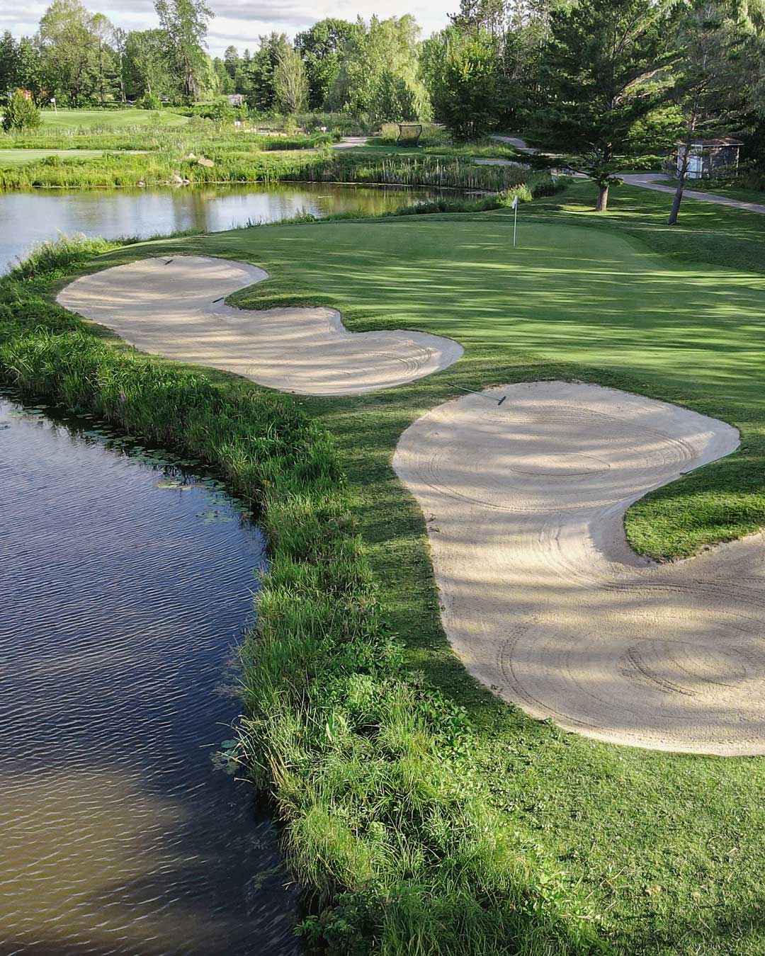 Muskoka golf green with two bunkers and water
